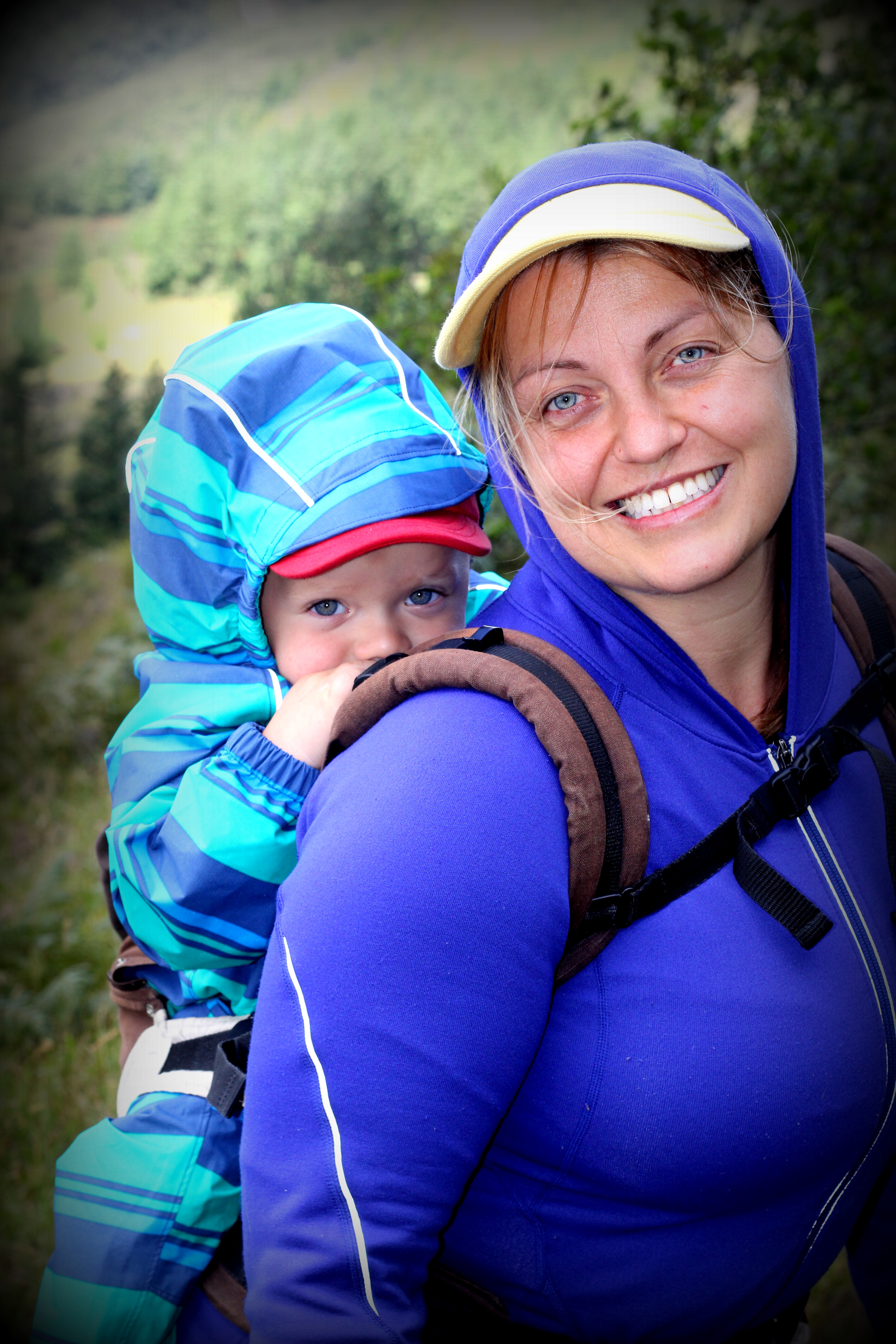 Joanna smiling with her baby on her back, hiking in Ecuador